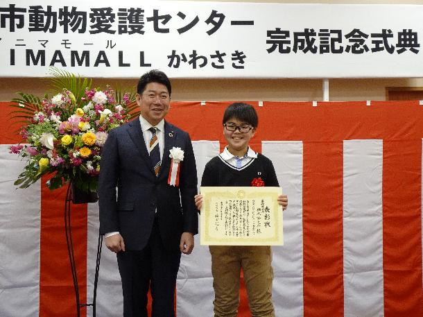 「ANIMAMALL（アニマモール）かわさき」の愛称を考案した小学生と記念撮影をする市長