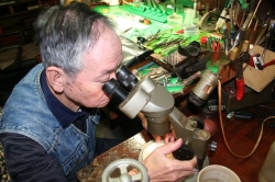 飯島さん顕微鏡を見ながらの作業風景写真