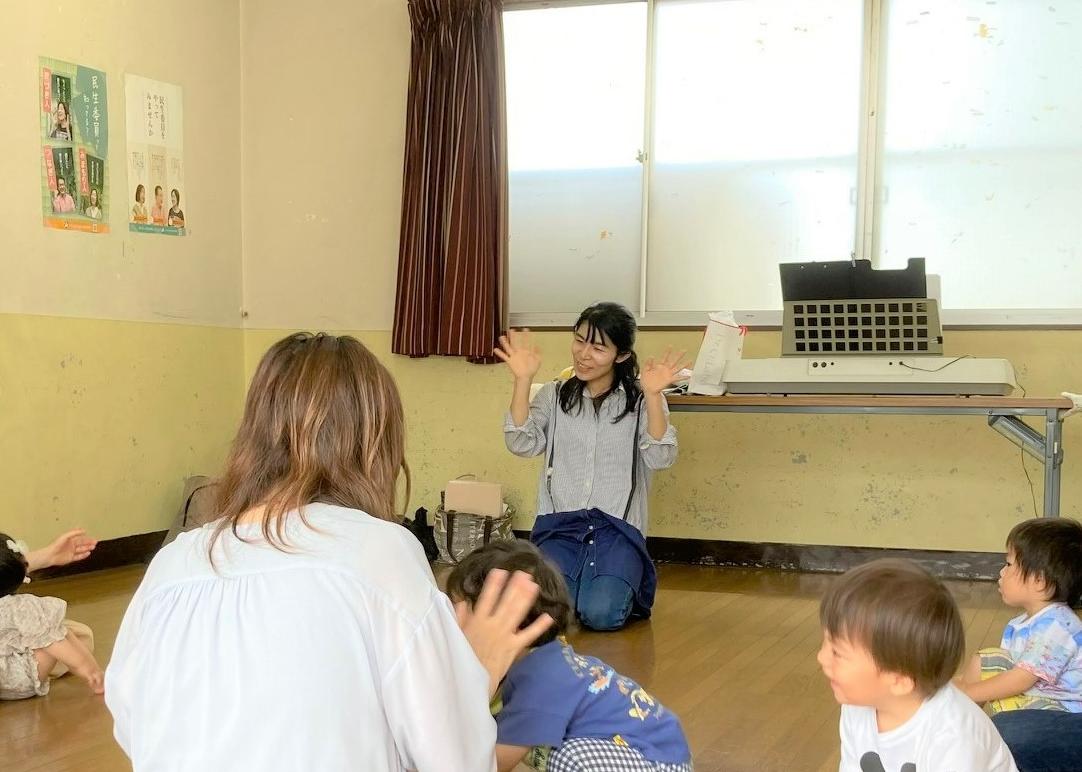 子育てボランティアが乳幼児親子にリトミックを披露している