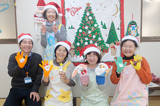 写真　前列左から今井保健師、久米さん、野上さん、山口さん、後列立っているのが佐藤さん。パペットは野上さんの手作り