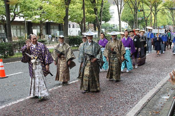 城主に扮し手を振りながらパレードに参加する市長