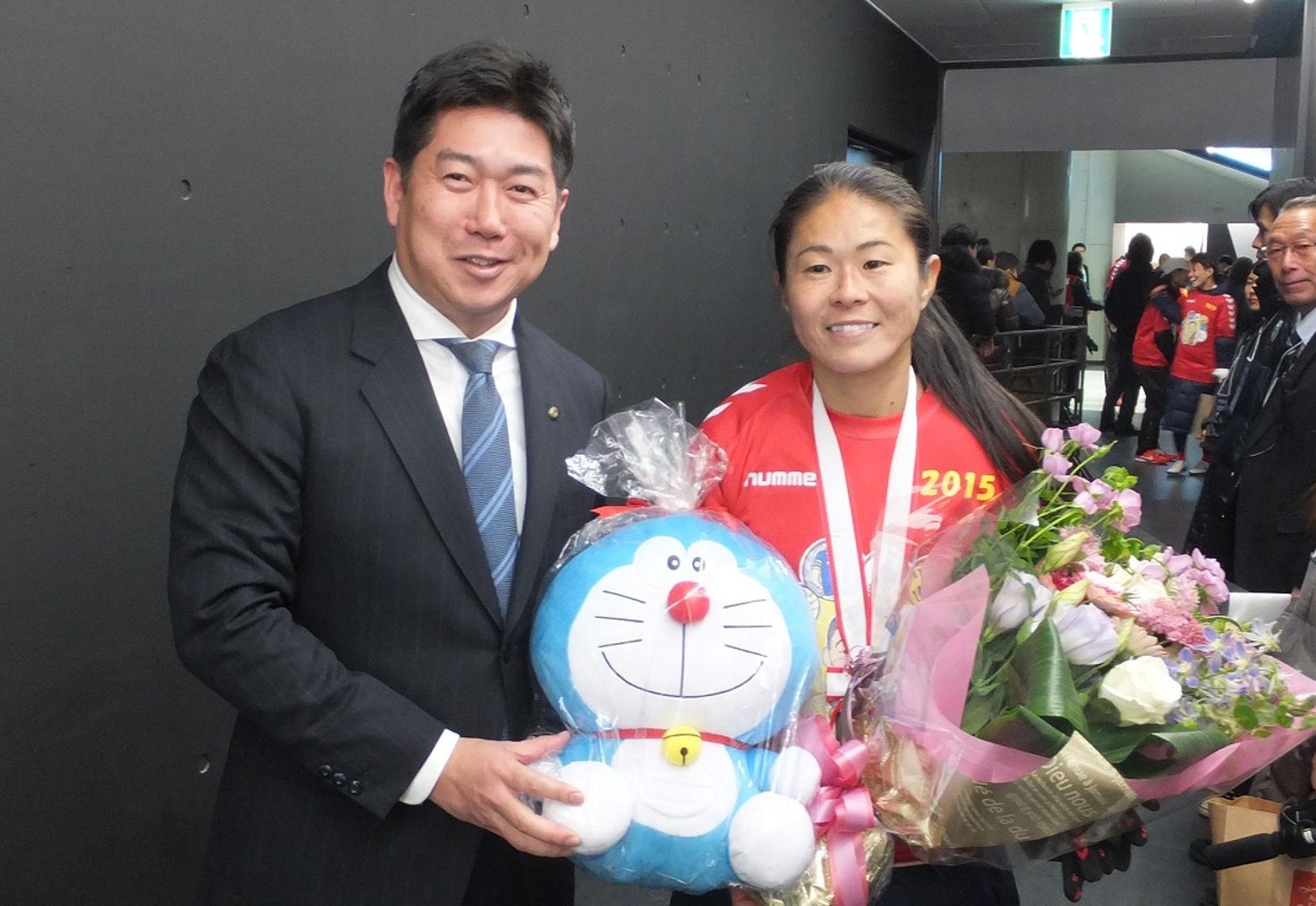 澤選手に花束とドラえもんのぬいぐるみを贈呈する市長