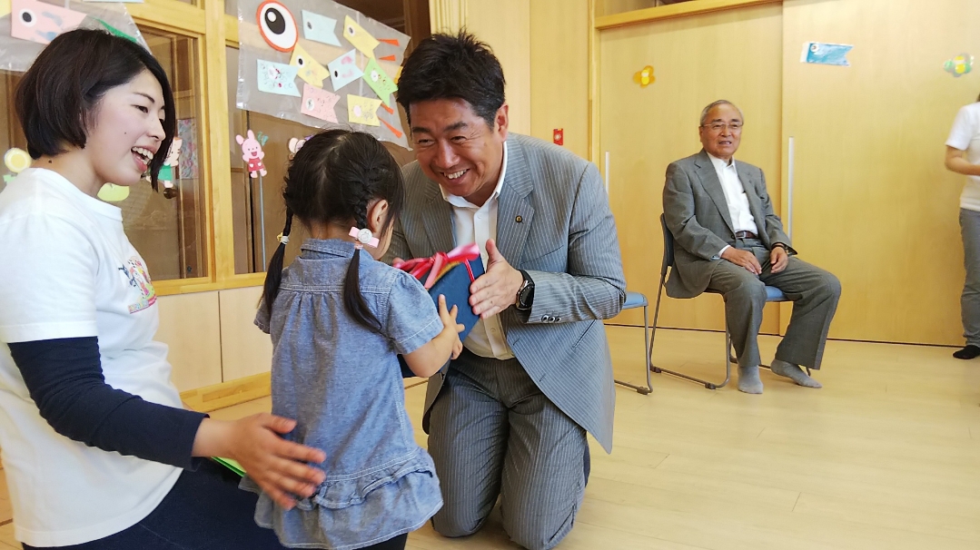 子どもにプレゼントを手渡する市長