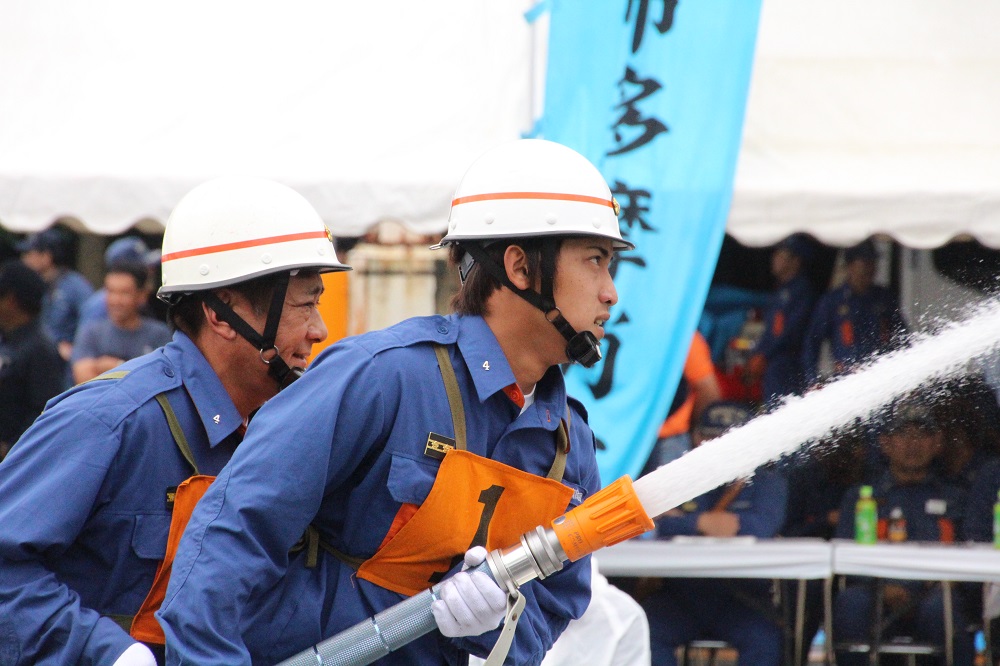 迅速な消火活動を競い合う消防団員