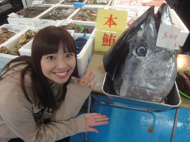 【写真】プレゼンターとマグロの頭が写っています。