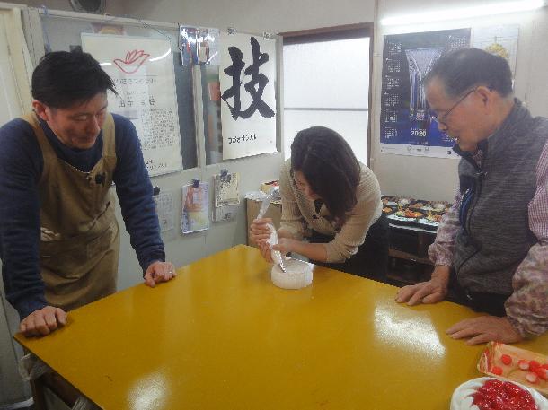 【写真】プレゼンターが食品サンプル作りを体験している様子が写っています