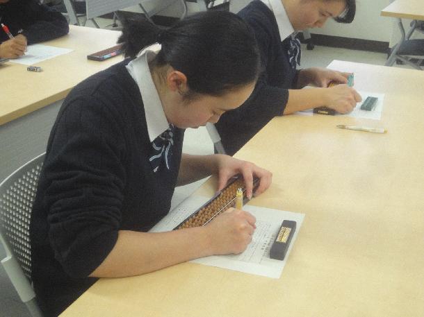 【写真】珠算部の学生が珠算をしています。