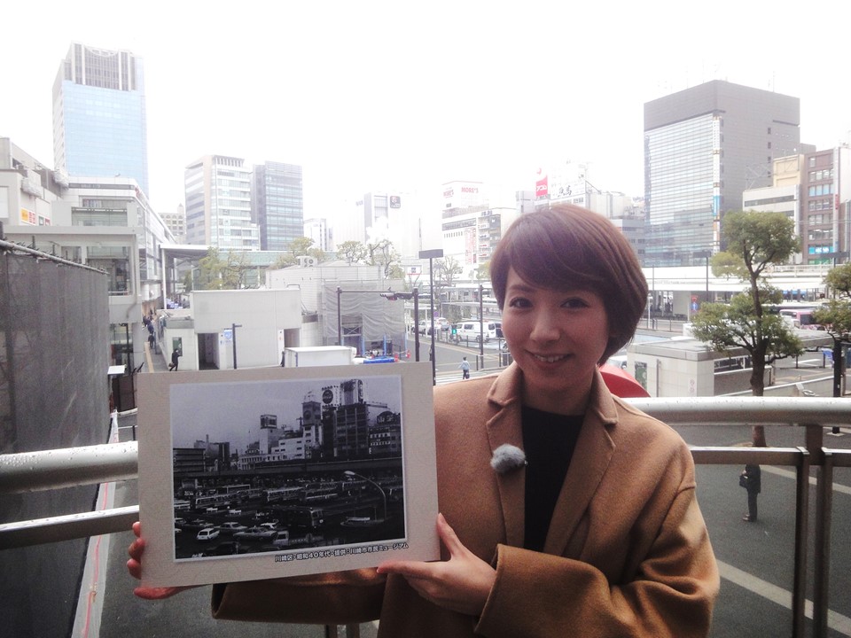 【写真】プレゼンターが昭和40年代の川崎駅周辺の写真を持っています。