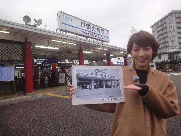 【写真】プレゼンターが川崎大師駅前にたっています。