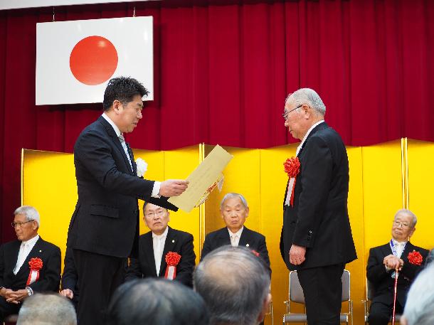 賞状と記念品を贈呈する市長