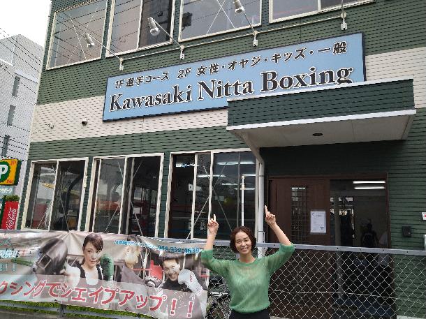 【写真】川崎新田ボクシングジムをバックにプレゼンターが写っています。