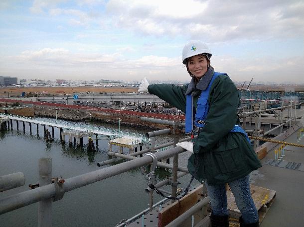【写真】プレゼンターが橋の上から空港を見ています