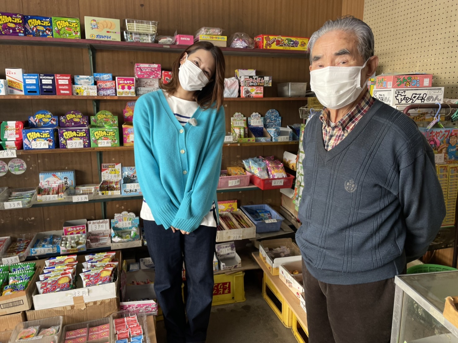 【写真】駄菓子屋さんで、左にプレゼンター、右に店主さんが写っています。