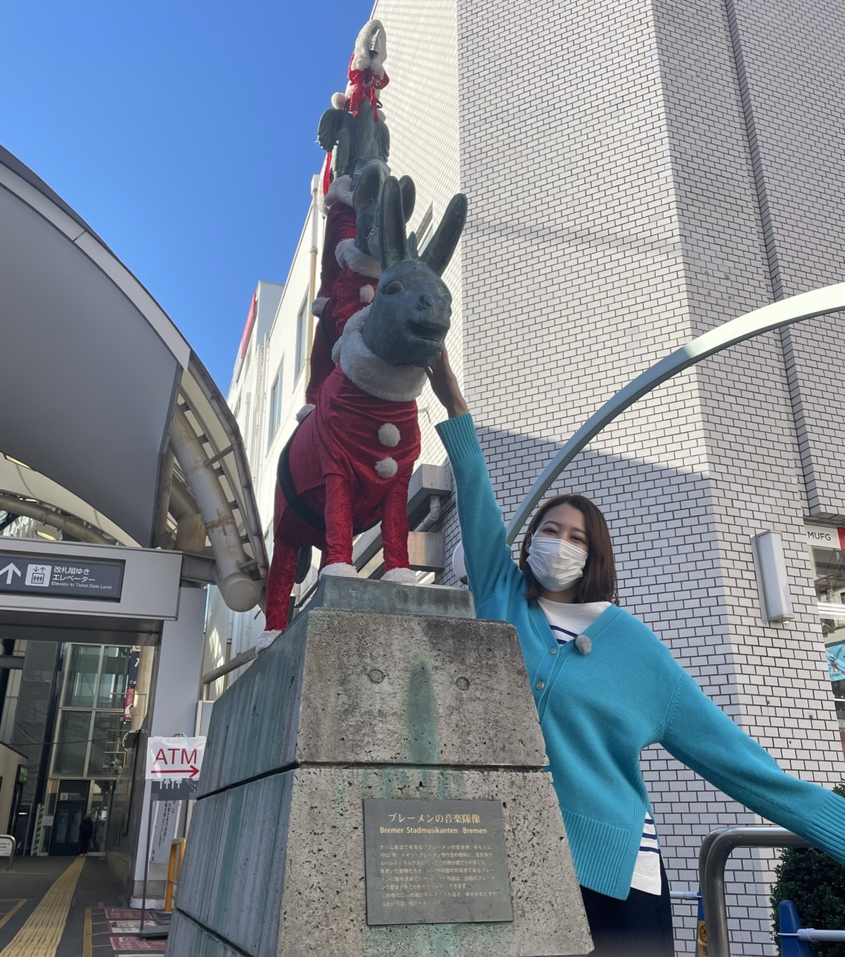 【写真】東急元住吉駅前の「ブレーメンの音楽隊像」前でプレゼンターが写っています。