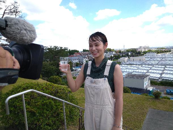 【写真】浄水したての水を飲むプレゼンターが写っています