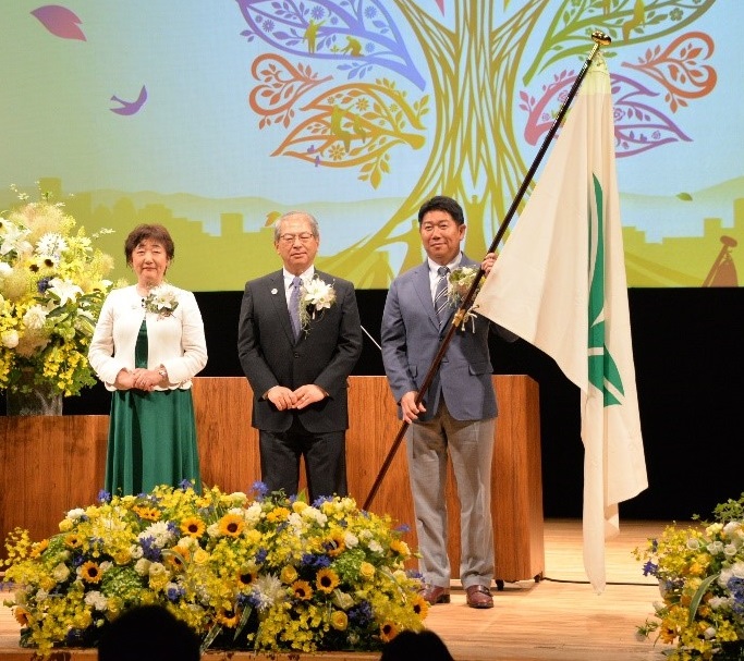 写真1：フェア旗を引き継いだ市長（左：郡仙台市長　中央：横張都市緑化機構理事長）
