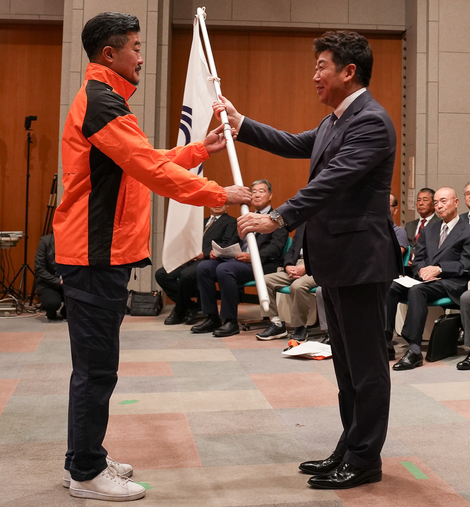 写真2：選手に激励の言葉を贈り団旗を渡す市長
