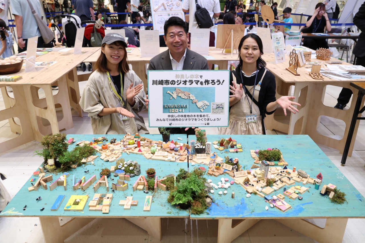 子どもたちが作った川崎市のジオラマと記念写真を撮る市長