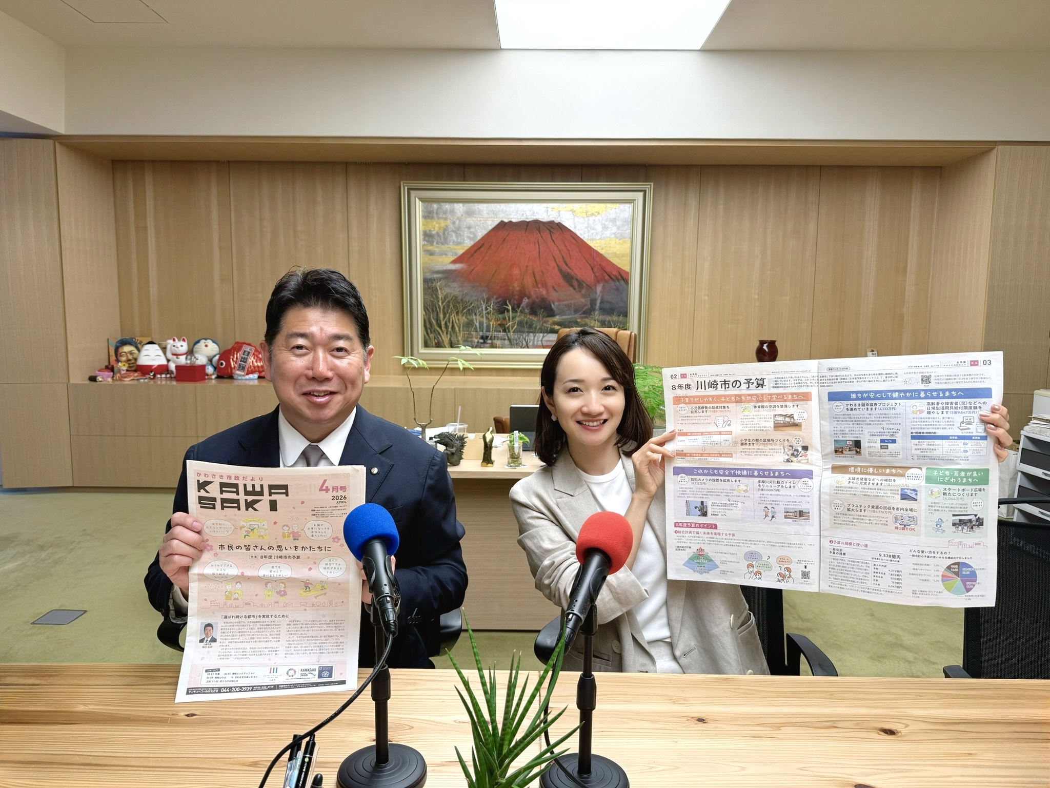 写真1:市政だよりを手に持つ市長と松原江里佳さん
