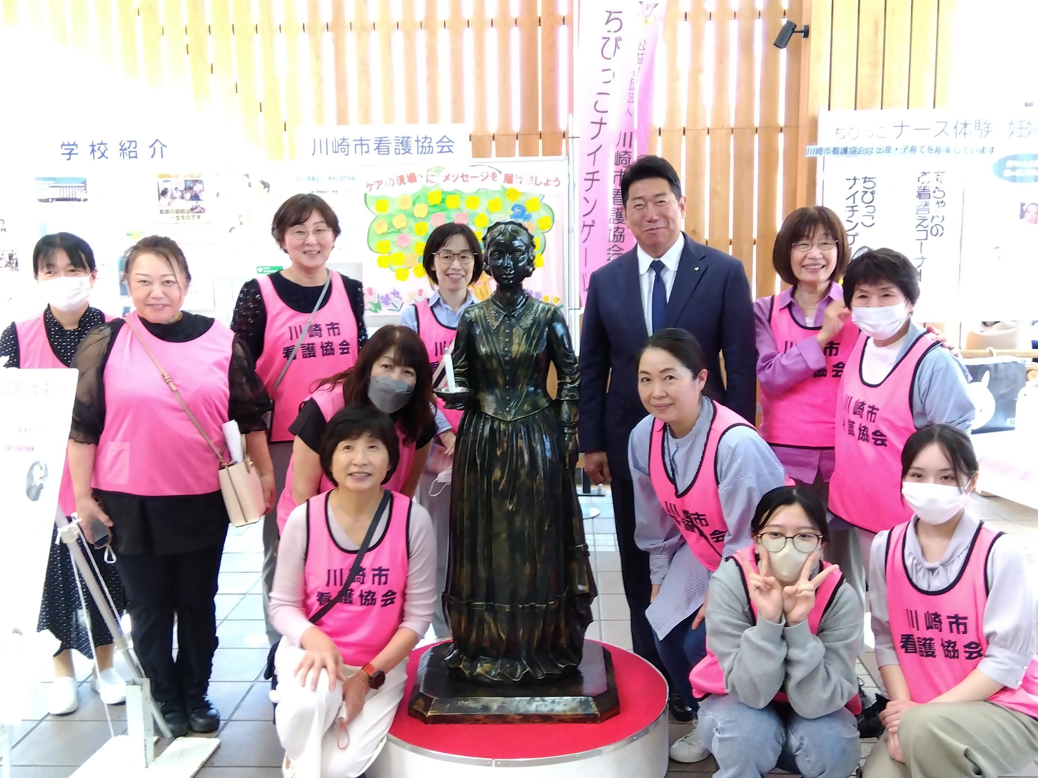 写真1:ナイチンゲール像の前で看護協会のスタッフとともに写真を撮られる市長