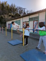 子供たちが鉄棒で遊ぶ写真