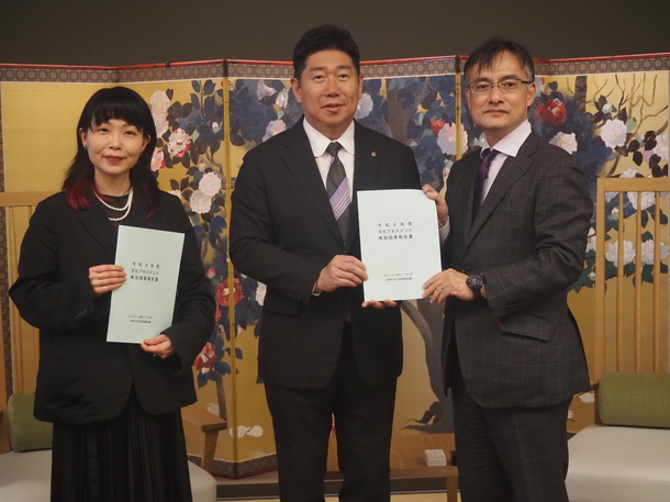 報告書を手に。会長、市長と副会長