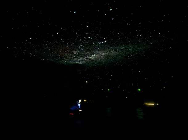 室内にプラネタリウムの装置から映し出された満天の星