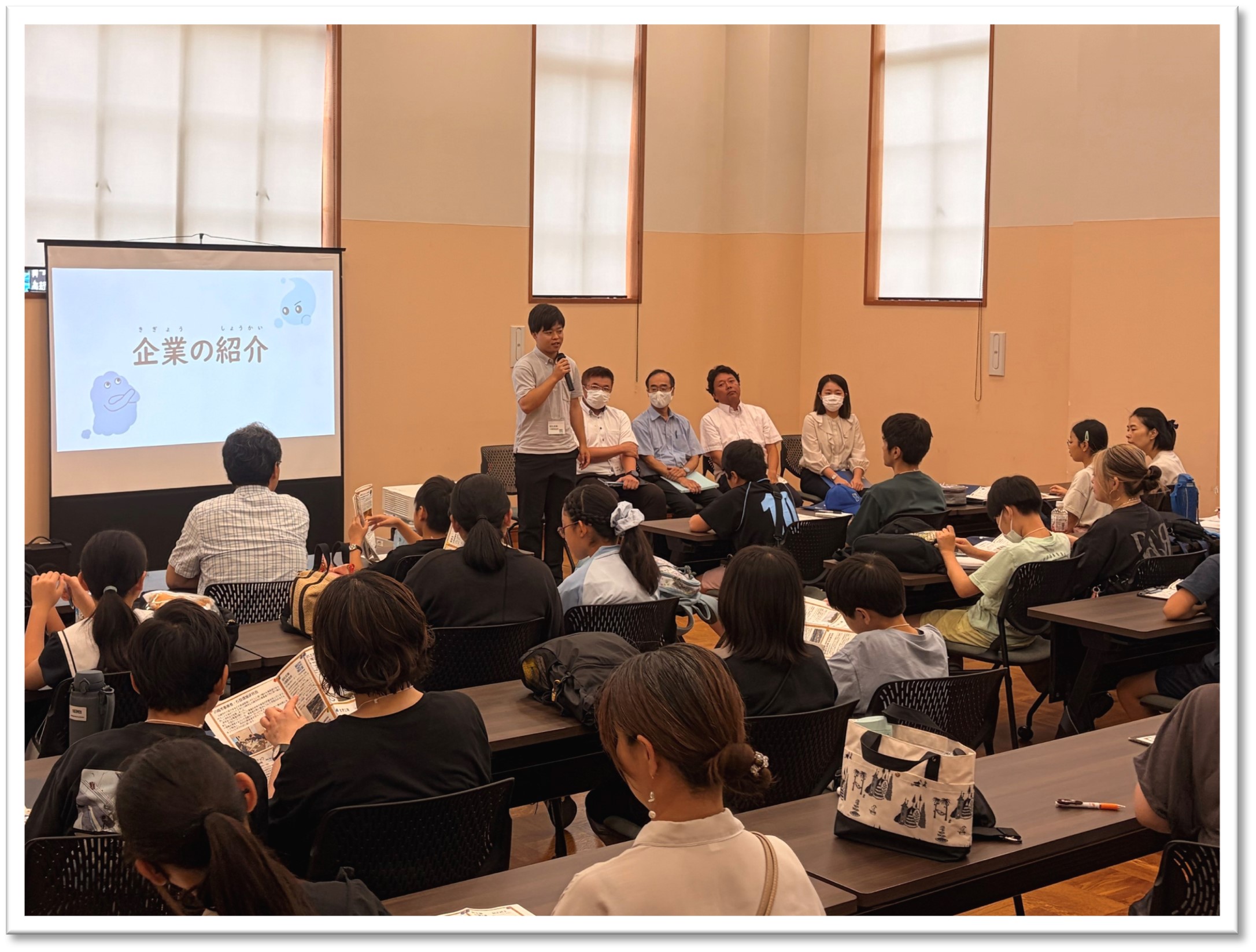 バスツアーのオリエンテーションで事業者が自身の企業についてそれぞれ紹介しているのを参加者が聞いている様子