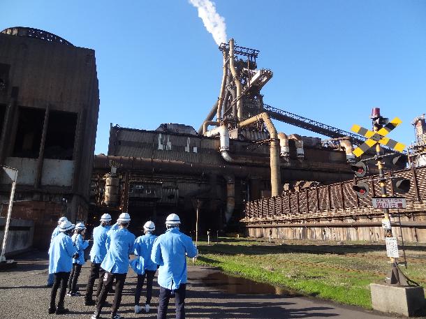 製鉄所のシンボルである高炉を見学。原料である鉄鉱石とコークス（石炭を蒸し焼きにしたもの）を入れて約1,200℃の熱風を吹き込み、銑鉄を作る。