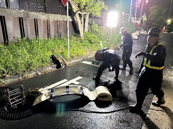 排水準備のため、マンホールにホースをつないだ