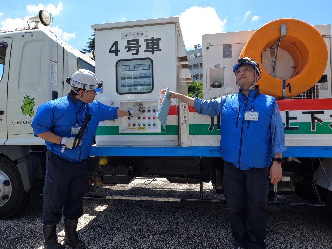 排水ポンプ車の操作方法の説明をしています。