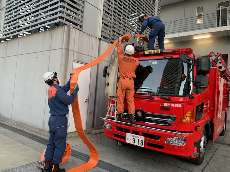 大型ホースをホース延長車に収納する写真