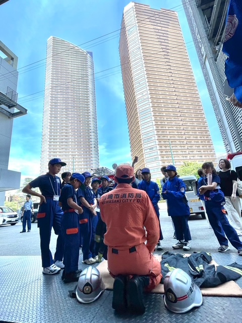 防火衣の説明を受けるクラブ員たちの写真