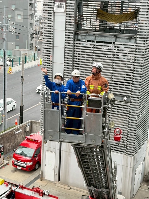 はしご車から手を振るクラブ員の写真