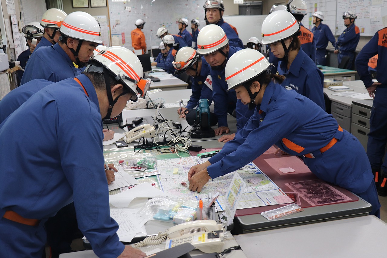 出場部隊の位置を示す女性消防団員の様子