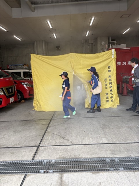 煙の中から出てくる少年消防クラブ員