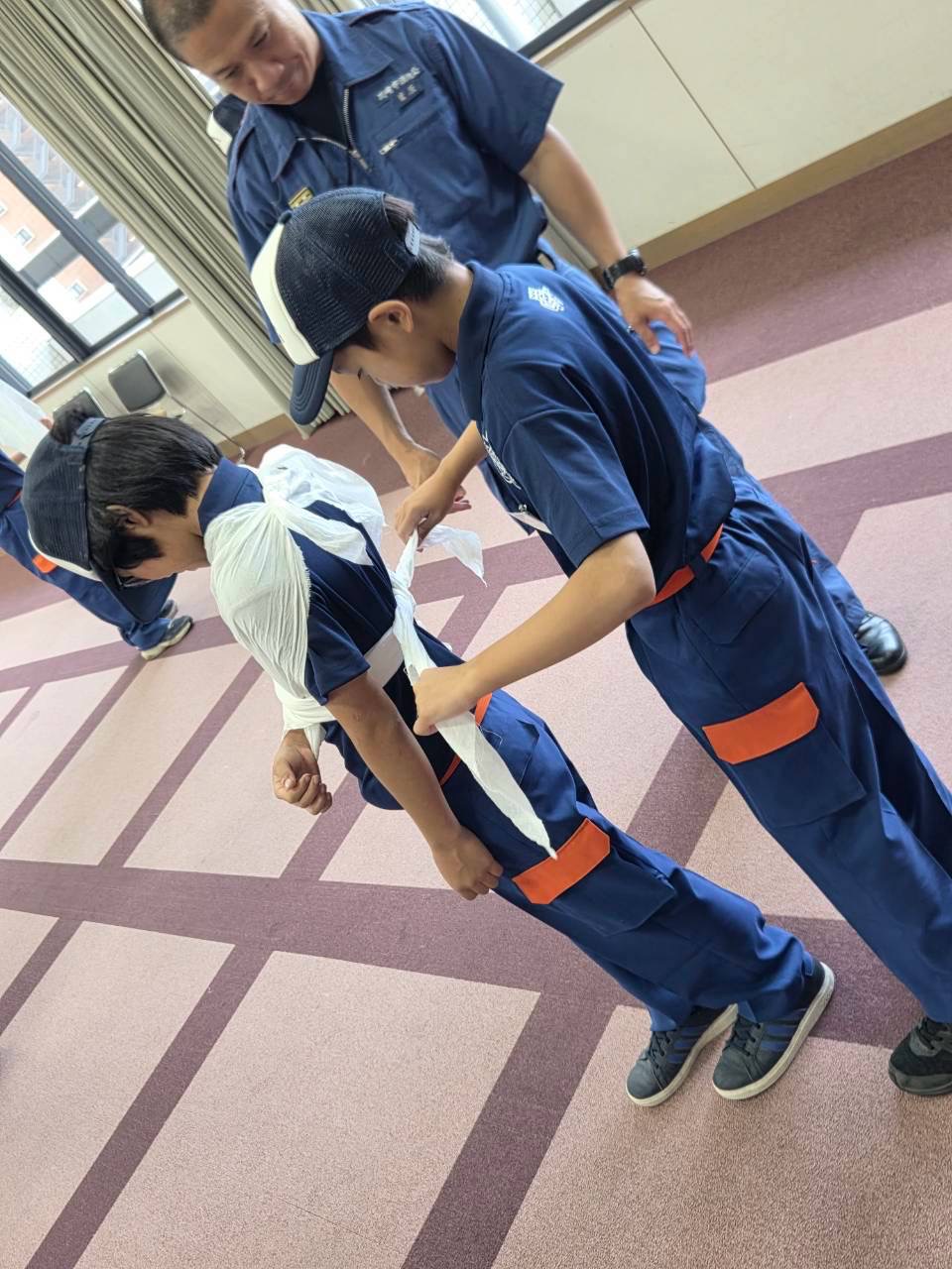 三角巾を結ぶ少年消防クラブ員