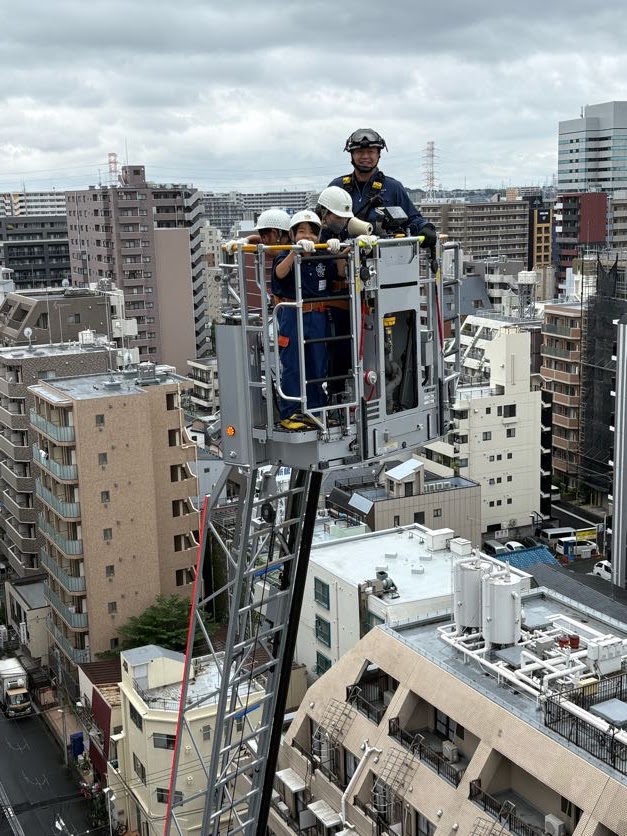 はしご車に乗るクラブ員