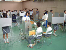 投票用紙を投票箱に入れる生徒