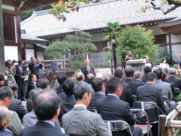 除幕式であいさつする水野柿生禅寺丸柿保存会会長