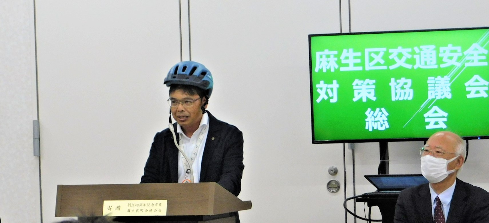 自転車用ヘルメットを着用し挨拶する岸副区長