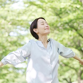 両手を広げて気持ち良く呼吸をしている女性