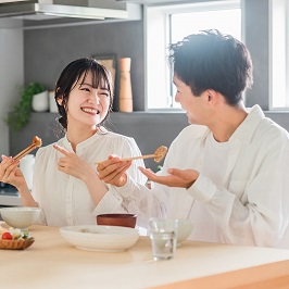 並んで笑顔で食事をしている男女