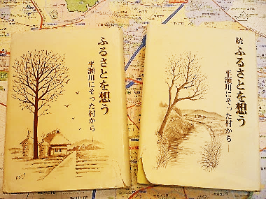 「ふるさとを想う 平瀬川にそった村から」とその続編の2冊の本の写真。表紙はどちらも平瀬川と周りの風景が描かれている。