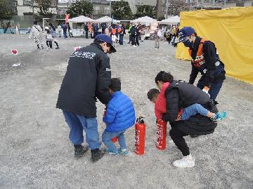 水消火器を使った消火訓練を子供が実施しています。