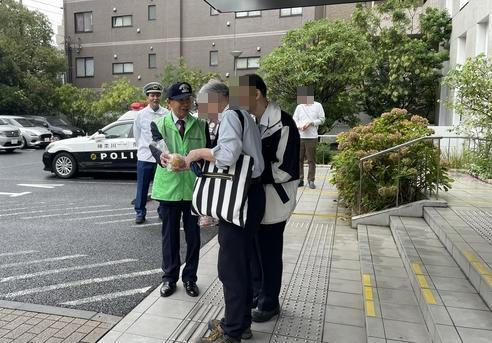 来庁者へ手渡す鹿島会長