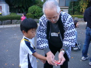 コマの投げ方を教わる子ども